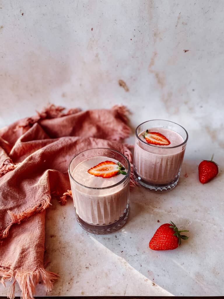 two glasses of pink strawberry oat breakfast smoothie